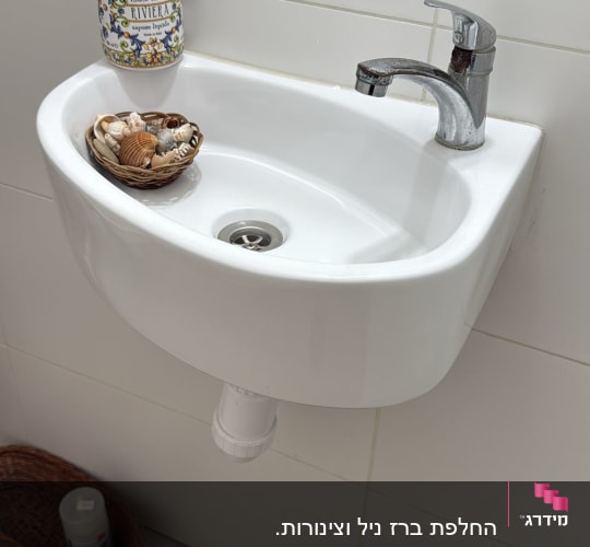 כיור עם ברז וסבון נוזלי בחדר אמבטיה